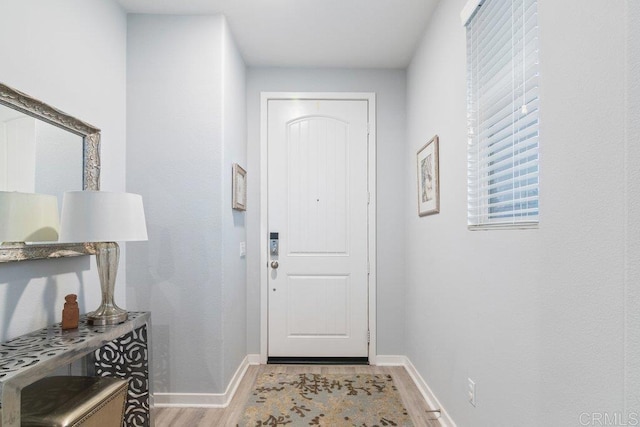 entryway with light wood finished floors and baseboards