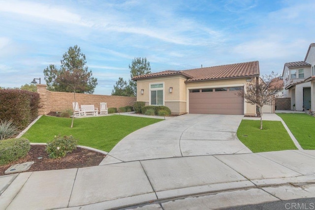 mediterranean / spanish-style house with stucco siding, driveway, a tile roof, a front yard, and a garage