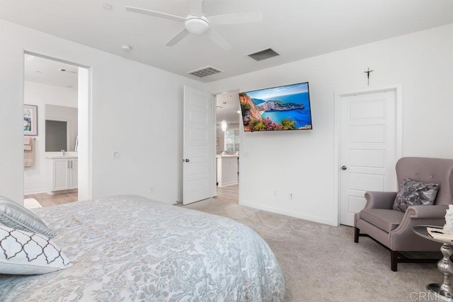 bedroom featuring ensuite bath, baseboards, visible vents, and light carpet