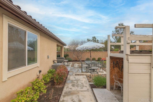 view of patio featuring outdoor dining space and fence