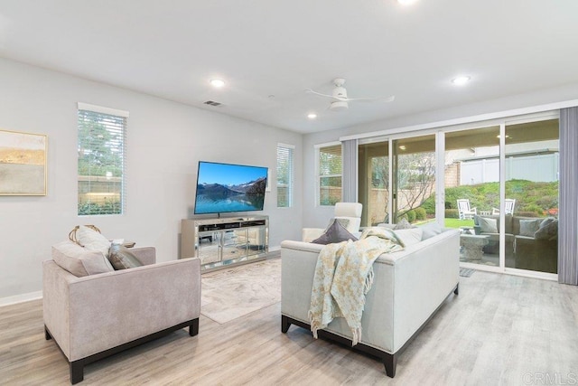 living room featuring recessed lighting, a healthy amount of sunlight, and light wood-type flooring