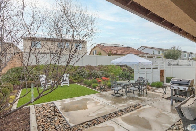 view of patio with outdoor dining space, a fenced backyard, and grilling area