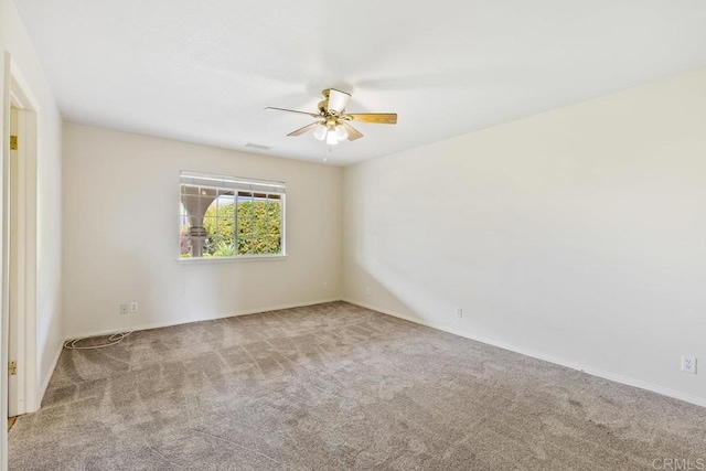 spare room with carpet, visible vents, and ceiling fan