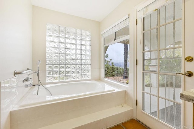 bathroom with a wealth of natural light and a bath