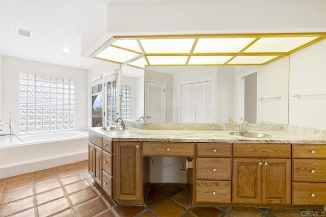 bathroom featuring a sink, visible vents, a garden tub, and double vanity