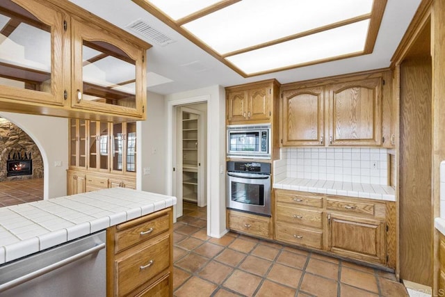 kitchen with visible vents, tasteful backsplash, appliances with stainless steel finishes, and tile counters