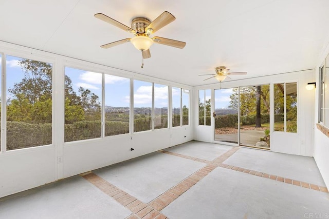 unfurnished sunroom with a ceiling fan