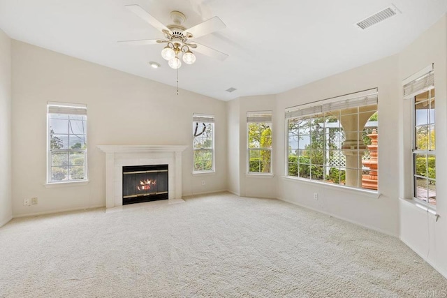 unfurnished living room with visible vents, plenty of natural light, and carpet