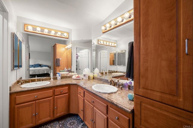 bathroom featuring a sink, double vanity, and ensuite bathroom