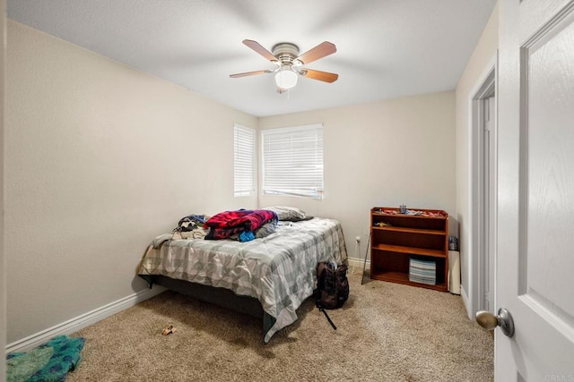 carpeted bedroom with ceiling fan and baseboards