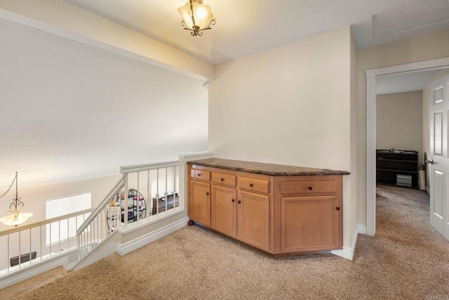 corridor featuring light carpet, an upstairs landing, and baseboards