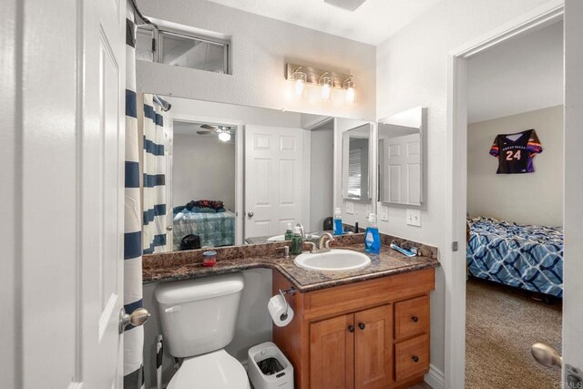 ensuite bathroom featuring a ceiling fan, toilet, ensuite bath, and vanity