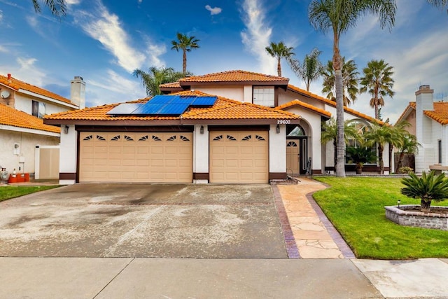 mediterranean / spanish house featuring a tile roof, concrete driveway, a garage, and stucco siding