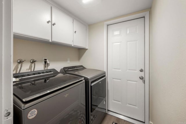 washroom featuring cabinet space, separate washer and dryer, and wood finished floors