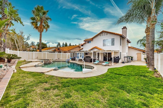 back of property with a patio, a fenced backyard, a yard, an in ground hot tub, and a chimney