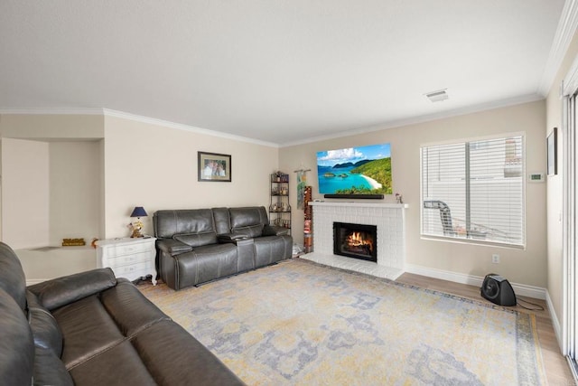 living room featuring visible vents, a brick fireplace, baseboards, ornamental molding, and wood finished floors