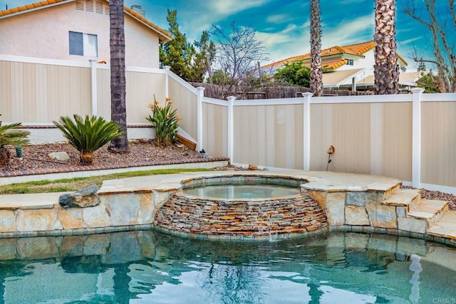 view of pool with a fenced in pool, an in ground hot tub, and a fenced backyard