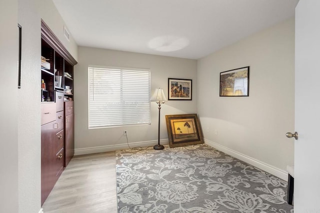 sitting room with baseboards and light wood-style flooring