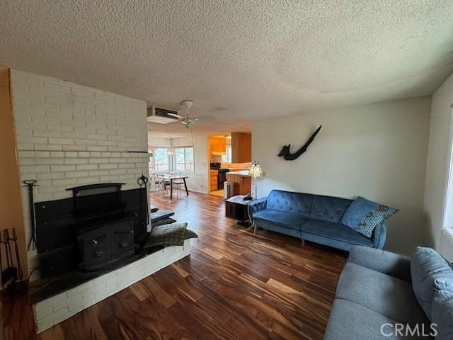 living area featuring a textured ceiling, wood finished floors, and a ceiling fan