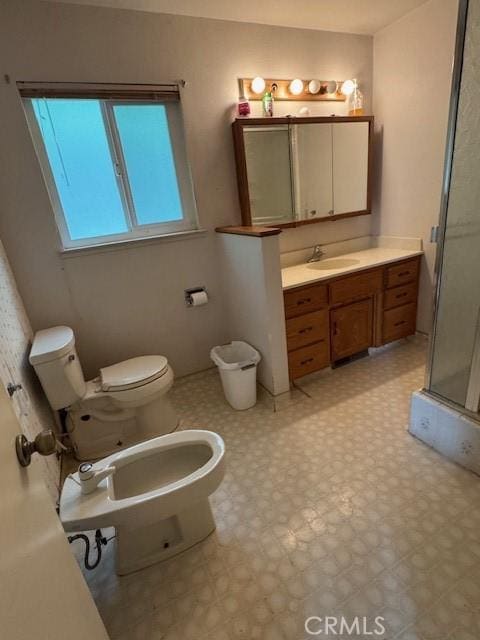 bathroom featuring a shower stall, toilet, a bidet, tile patterned floors, and vanity