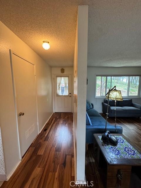 entryway featuring a textured ceiling and wood finished floors