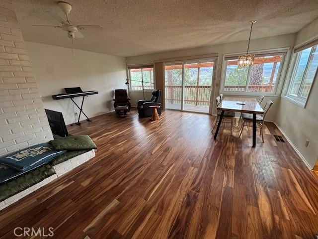 unfurnished dining area featuring dark wood finished floors, visible vents, and a textured ceiling