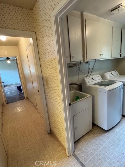 clothes washing area with a ceiling fan, visible vents, wallpapered walls, cabinet space, and washer and dryer