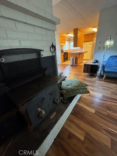 interior space featuring a textured ceiling, wood finished floors, and freestanding refrigerator