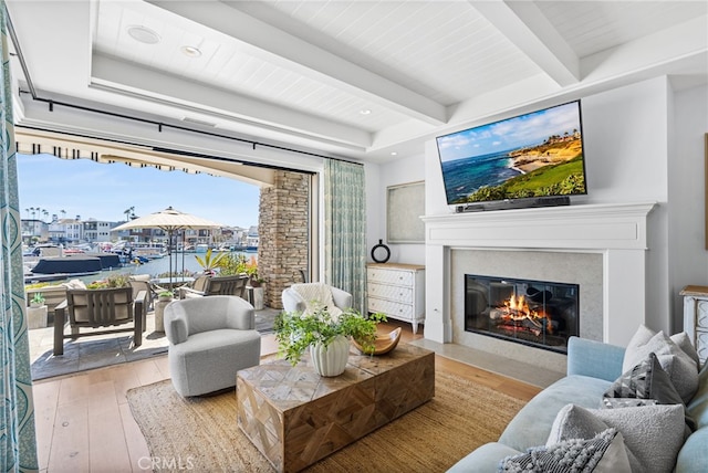 living area featuring beam ceiling, recessed lighting, a fireplace, and hardwood / wood-style flooring