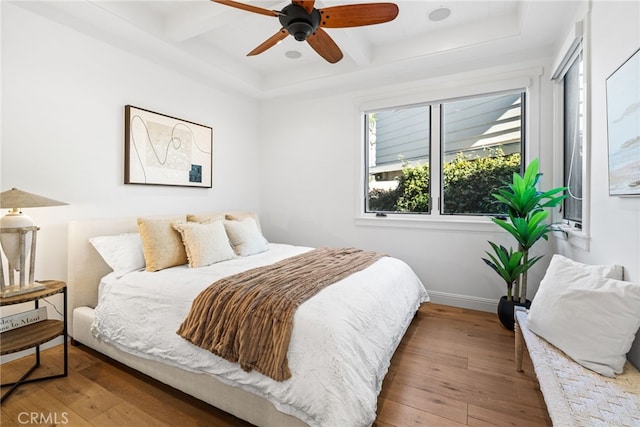 bedroom with beamed ceiling, coffered ceiling, baseboards, and wood-type flooring