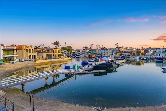 view of dock with a residential view and a water view