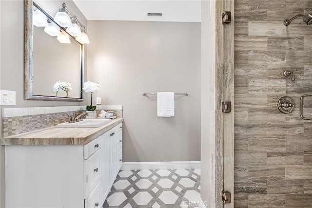 full bathroom with tile patterned floors, visible vents, a shower stall, baseboards, and vanity