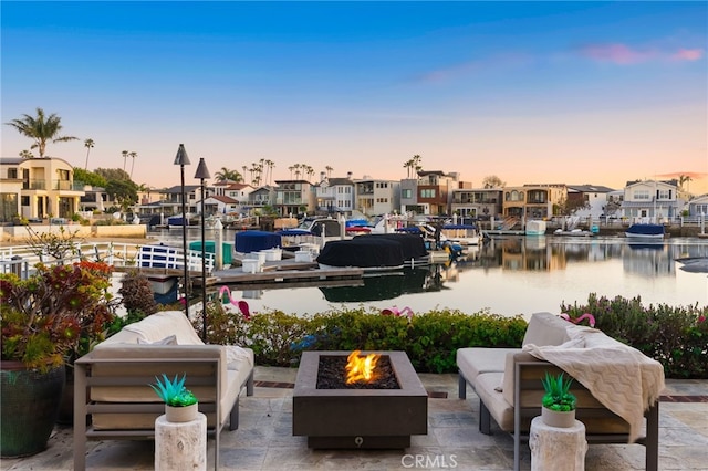 exterior space featuring a fire pit, a residential view, a water view, and a boat dock