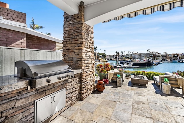 view of patio / terrace featuring area for grilling, a water view, and a grill