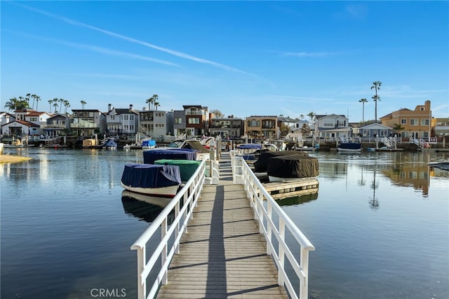 view of dock with a residential view and a water view