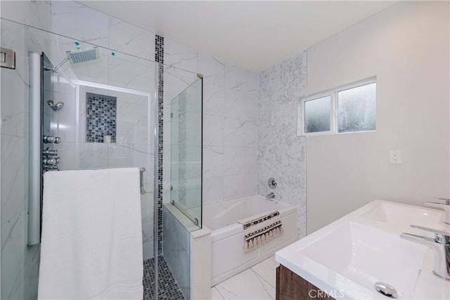 bathroom featuring marble finish floor, a stall shower, a garden tub, and a sink