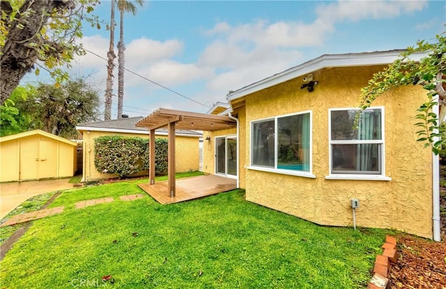 back of property featuring a shed, a pergola, stucco siding, an outdoor structure, and a lawn