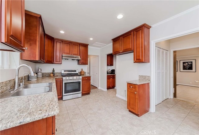 kitchen with a sink, under cabinet range hood, recessed lighting, crown molding, and gas range