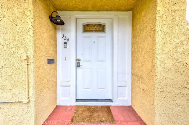 property entrance with stucco siding