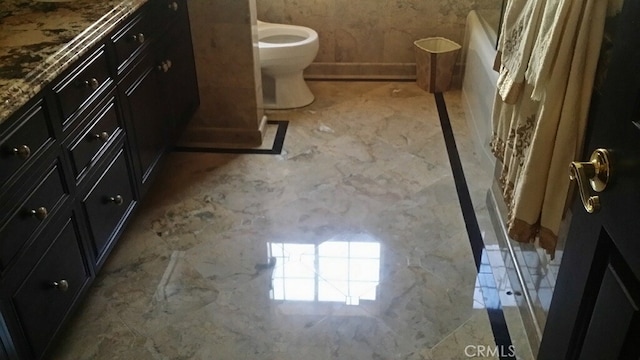 bathroom featuring marble finish floor, a washtub, toilet, and a shower