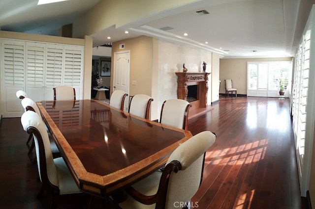 dining space with recessed lighting, visible vents, a fireplace with raised hearth, and dark wood-style floors