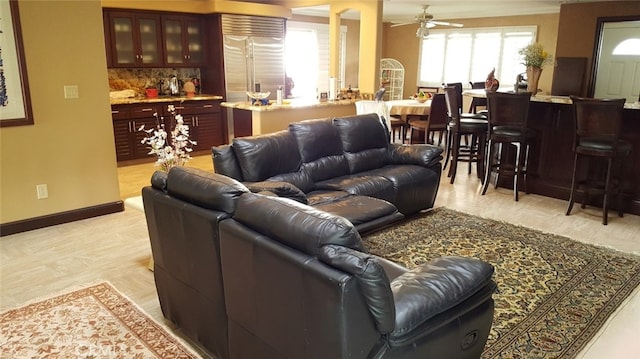 living room featuring baseboards and ceiling fan