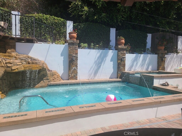 view of pool featuring fence and a hot tub