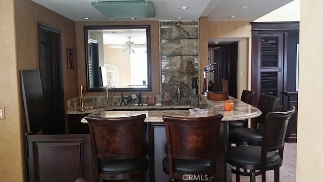 bar with wet bar and a ceiling fan