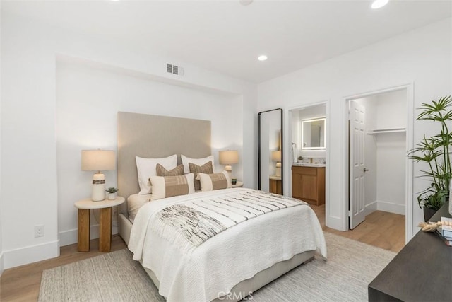 15 Cavaillon, Newport Coast, CA 92657 - bedroom featuring light wood-type flooring, recessed lighting, a walk in closet, connected bathroom, and a closet