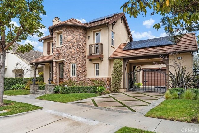 15 Cavaillon, Newport Coast, CA 92657 - view of front of property featuring stucco siding, a chimney, solar panels, stone siding, and driveway