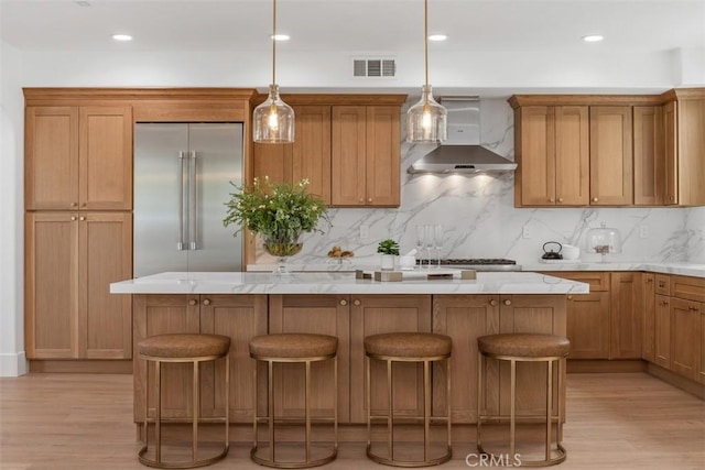 15 Cavaillon, Newport Coast, CA 92657 - kitchen with wall chimney range hood, built in fridge, a kitchen island, light wood finished floors, and decorative backsplash