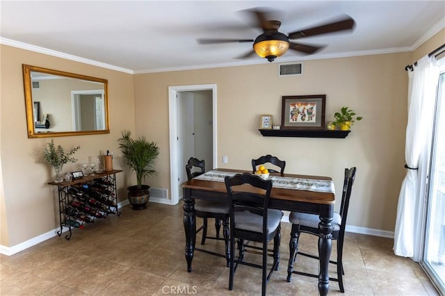 dining space featuring tile patterned flooring, visible vents, crown molding, baseboards, and a ceiling fan