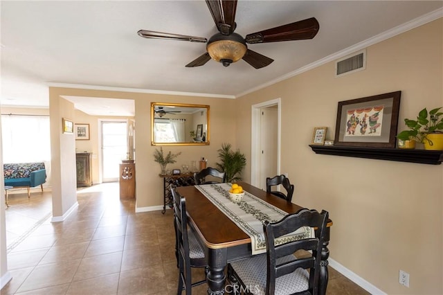 tiled dining area with visible vents, baseboards, a ceiling fan, and crown molding