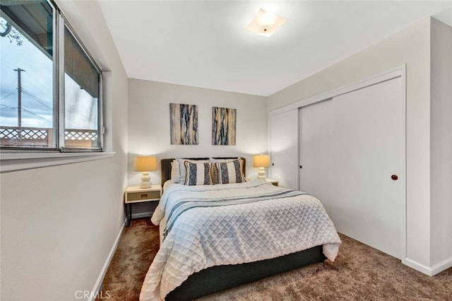 carpeted bedroom featuring baseboards and a closet